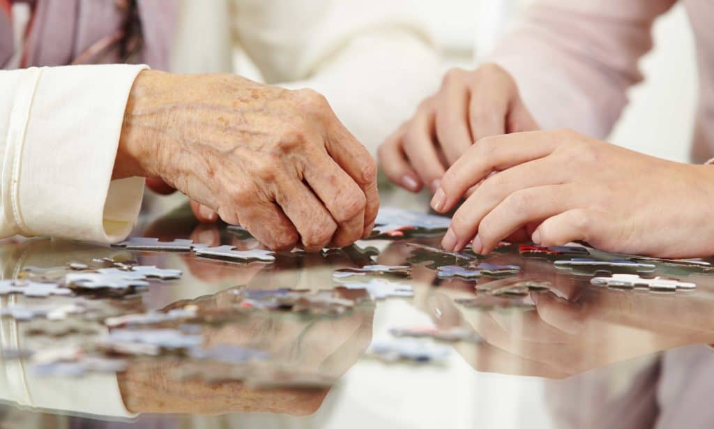 volunteer builds a puzzle with a patient
